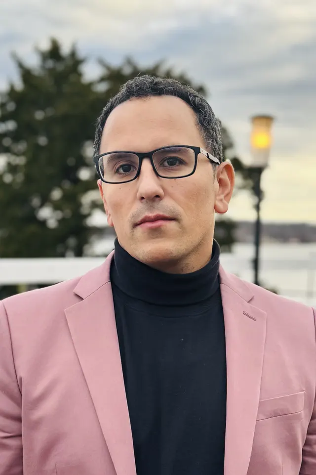 Danny Gutierrez wearing a mauve jacket and black turtleneck